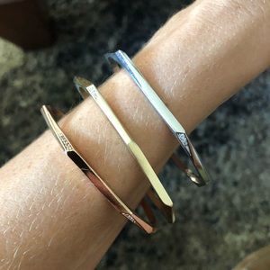 Kendra Scott three metal bangle bracelets.